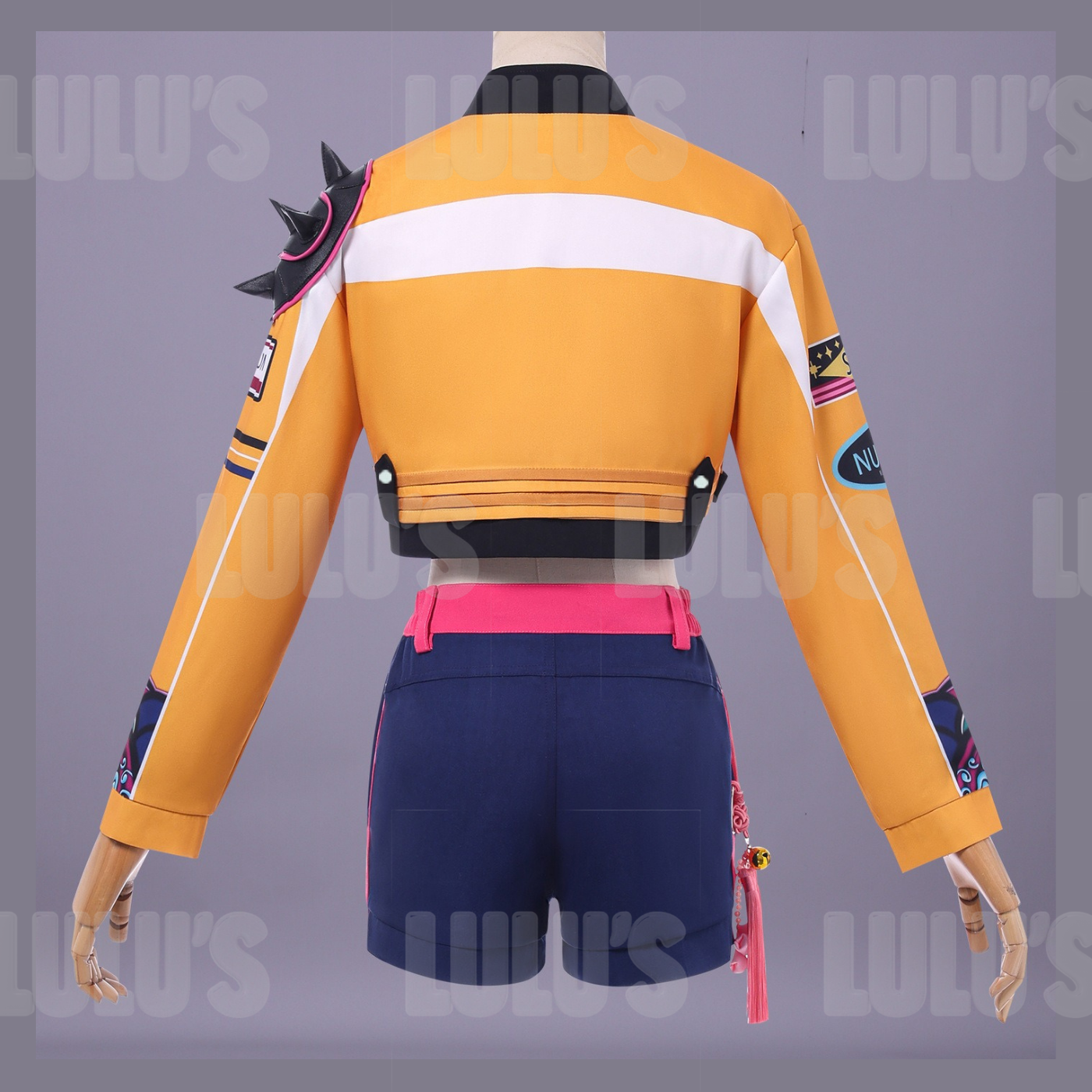 Back mannequin view of Rumi cosplay costume from Netflix K-Pop Demon Hunters showing orange jacket with black spikes and navy shorts with pink waistband.