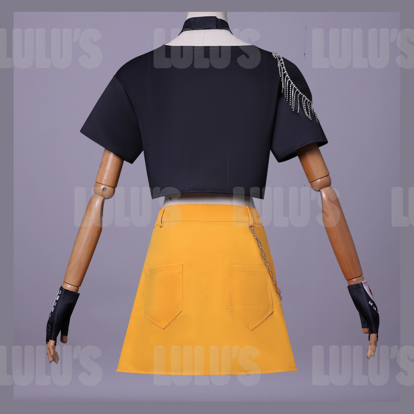 Back mannequin view of Mira cosplay costume from K-Pop Demon Hunters showing black crop top with shoulder detail and yellow skirt with chain belt.