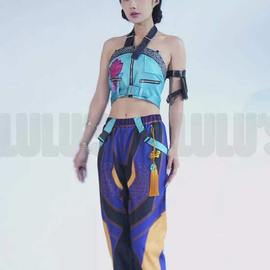 Video of a Model in K-Pop Demon Hunters Zoe cosplay costume striking character poses, featuring blue crop top, purple patterned jogger pants, tassel belt, and black arm band