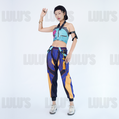 Female model wearing K-Pop Demon Hunters Zoe cosplay costume, blue floral crop top with zipper and purple gold pants, styled with character accessories.